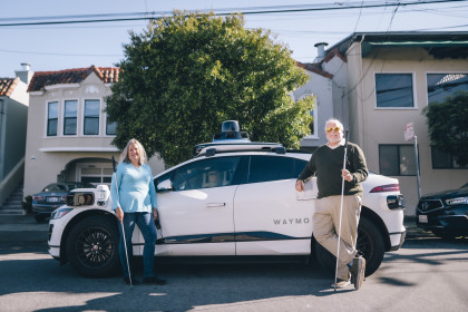 Community members in front of Waymo car