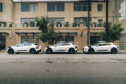 Three Waymo vehicles parked outside of Openhouse before heading out to deliver groceries to community members.